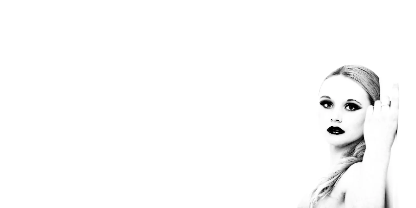 A pale face at the edge of a wide white frame nearly disappears.