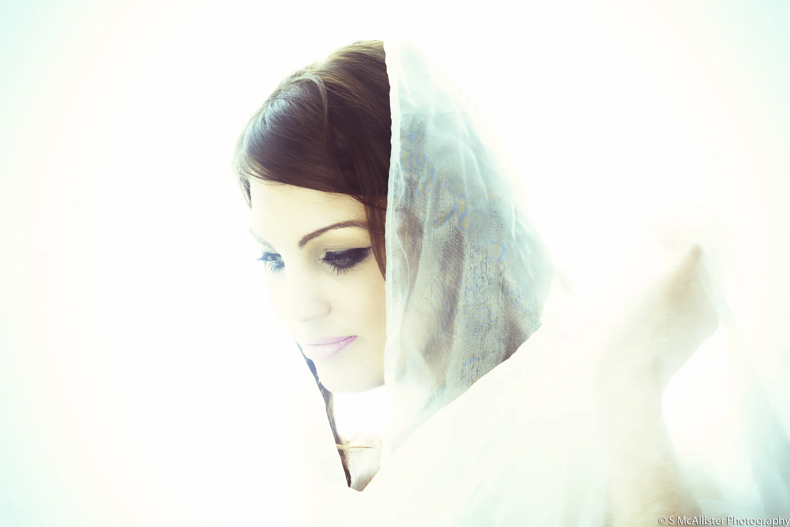 A woman wrapped in pale fabric is consumed by bright light.