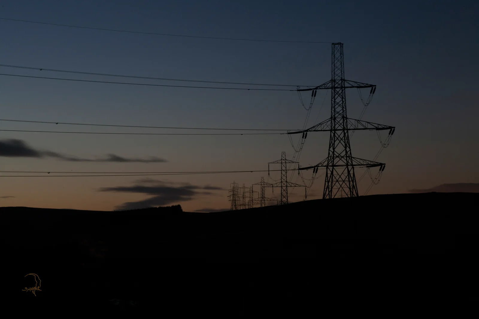 Power lines recede toward the horizon at dusk.