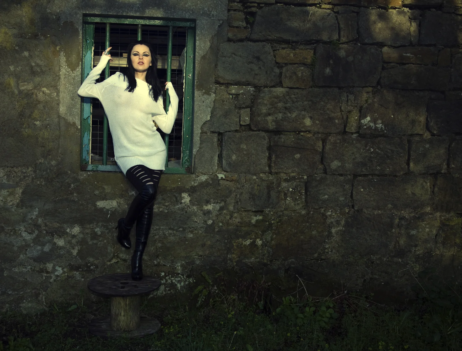 A woman’s presence appears held in the texture of a wall.